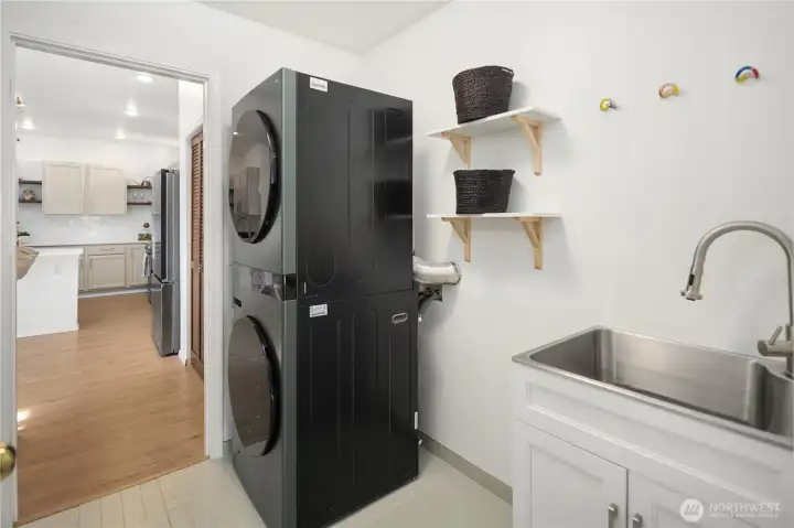 This laundry room was renovated in 2024 and features beautiful tile, new washer/dryer and a handy utility sink