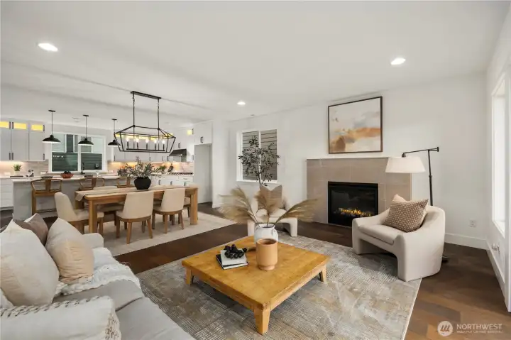 Great Room: Light-filled great room centers on a sleek gas fireplace framed by tile surround and expansive windows. The open layout blends comfort and sophistication, with direct flow to dining and kitchen for effortless entertaining.    Photos are from THIS model home at Foxmoore but are for visualization purposes only.