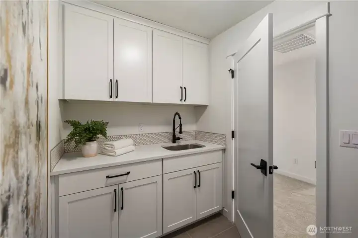 Laundry Room: Upper-level laundry includes cabinetry, sink, and counter workspace for added functionality. Washer and dryer not included, allowing buyers to select appliances that fit their needs.    Photos are from THIS model home at Foxmoore but are for visualization purposes only.