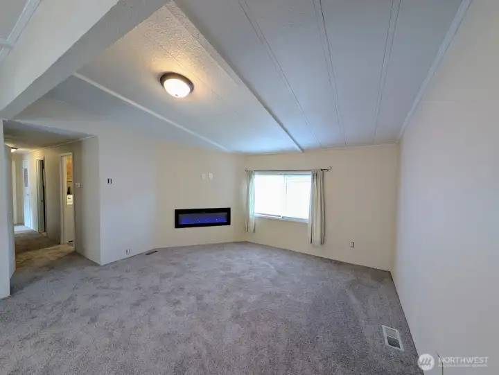 Vaulted family room w/new carpet, paint & electric fireplace.