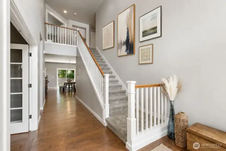 Foyer and stairs to second floor features vaulted ceilings. *Some art is digital.