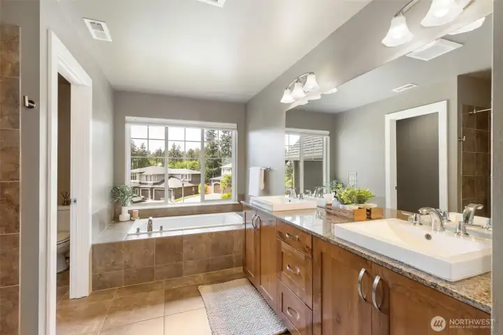 Primary suite full bath features dual sinks, soaking tub, separate shower, & water closet.