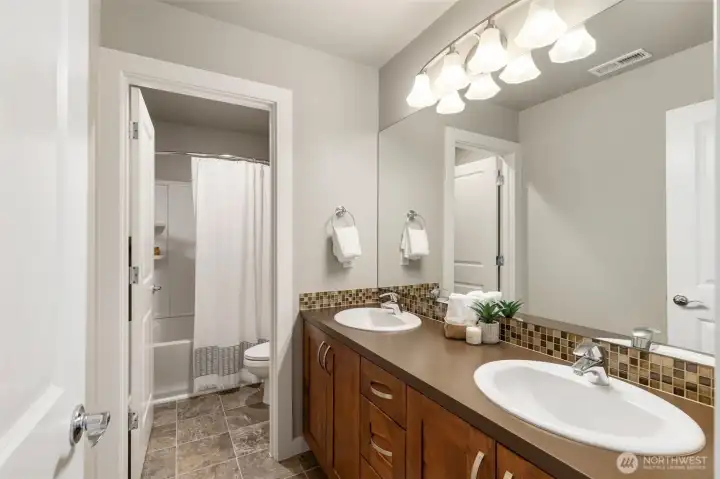 Second full bath on upper level, features DUAL sinks and separated areas for preparing for your day.
