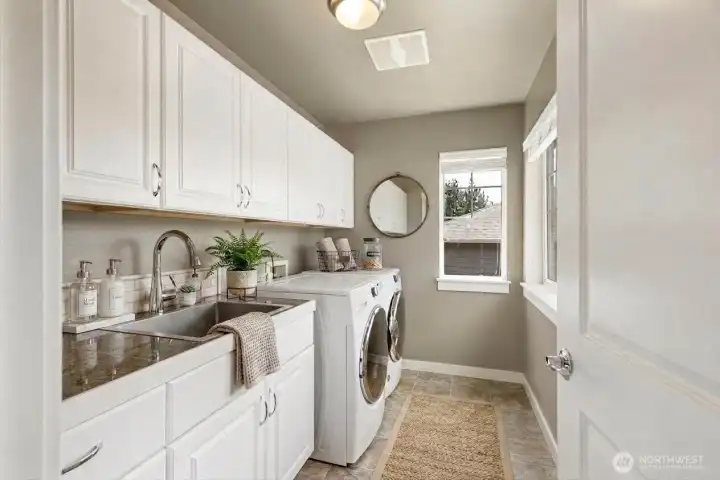 Fantastic laundry room with deep sink and lots of cabinets for storage. Washer and dryer stay (sold as-is).