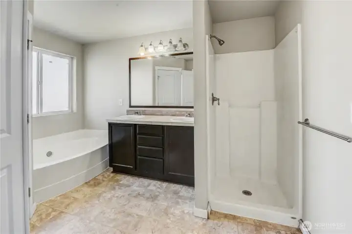 Primary en-suite full bath with soaking tub, separate walk-in shower and double sink vanity.