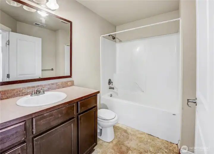 upstairs full bathroom across from the laundry room next to 2 of the bedrooms.