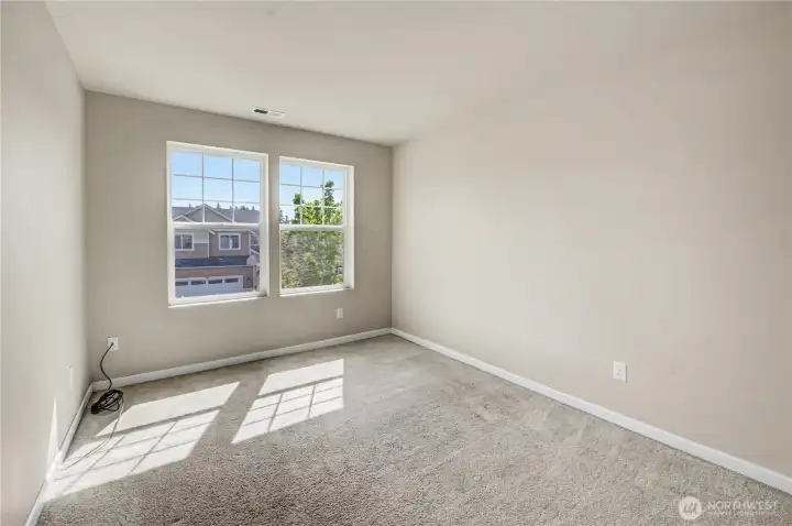 Bedroom on upper level with carpet flooring at front of house.