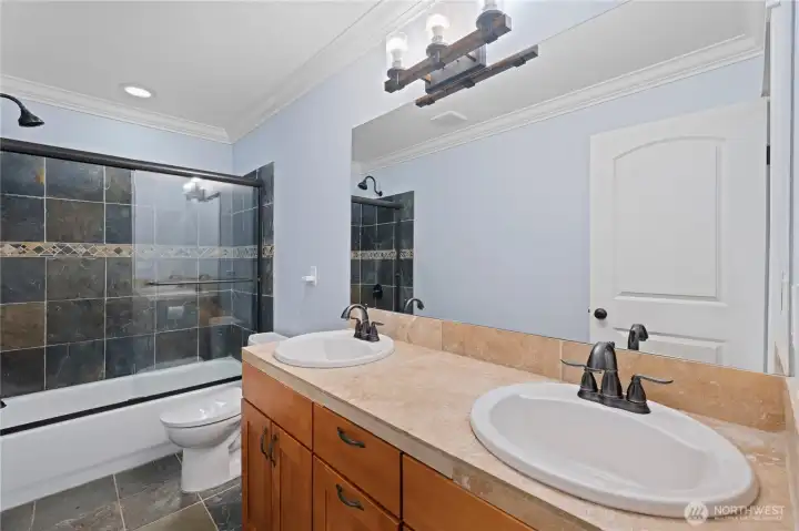 Upper-level full bath with double vanities.