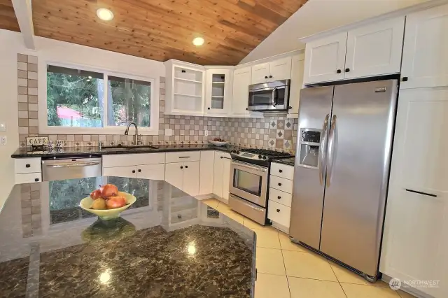 Slab granite counters & stainless steel appliances.