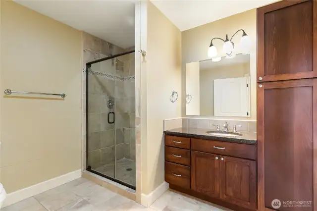 Guest bathroom with ample storage and walk-in shower.