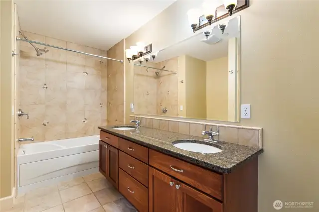 Primary ensuite bathroom with dual sinks, jetted tub, and additional walk-in shower.