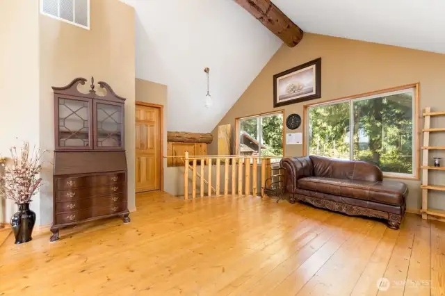 Eagle's view loft with natural light, vaulted ceiling overlooking home entrance.