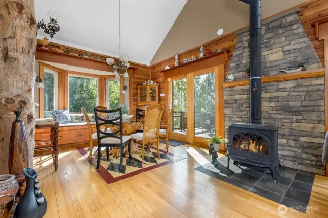Dining room with wood burning stove & vaulted ceiling.