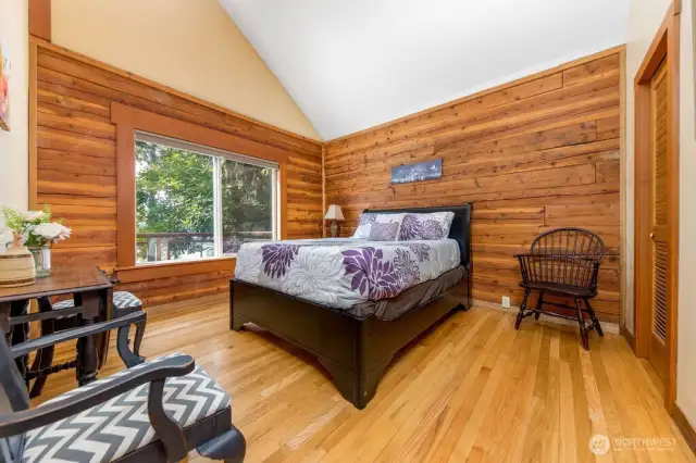 Primary bedroom with waterfront view, vaulted ceiling and walk-in closet.