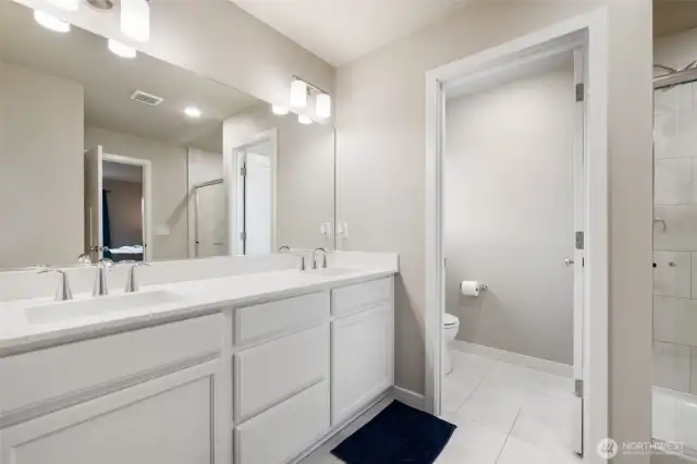 Enjoy a spacious en suite bath featuring dual sinks, a walk-in shower, and a private water closet — everything you need to start and end your day with ease.