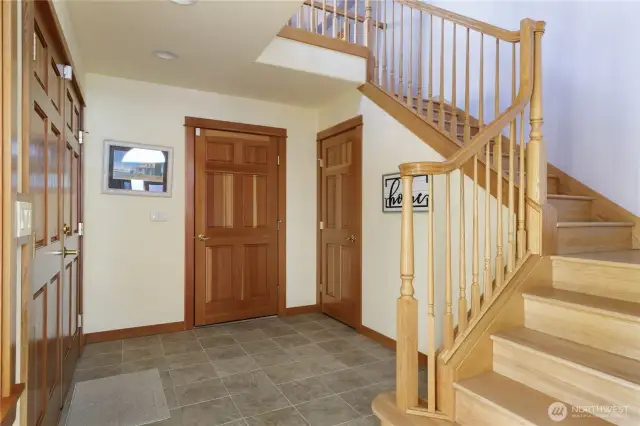 Enter into the foyer with 2 story ceiling and beautiful open wood staircase.  Door in middle leads to huge 3 car garage