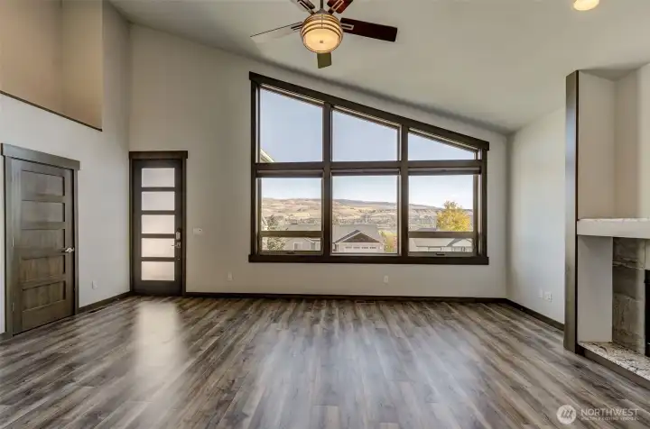 Expansive living room with floor-to-ceiling windows framing panoramic river views.