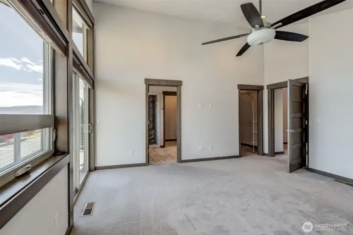 Spacious primary suite with solid wood doors and serene natural light.