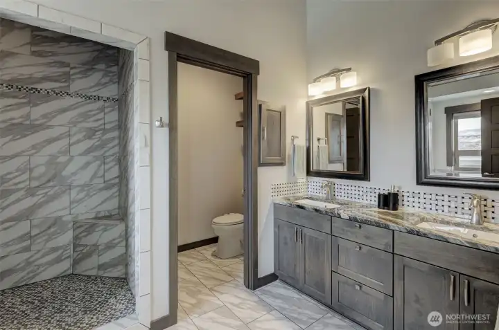 Luxurious primary bathroom with soaking tub and heated tile floors.