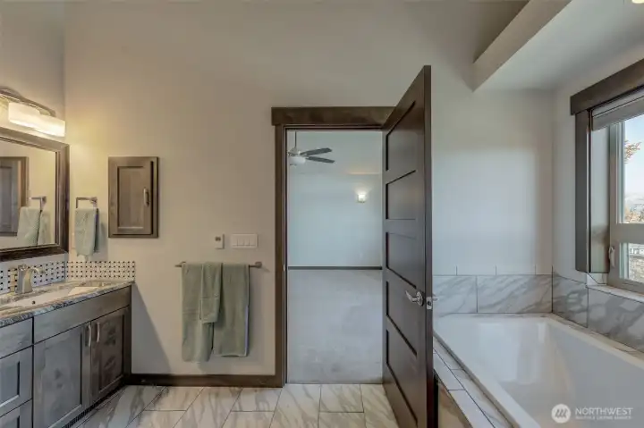 primary bathroom with soaking tub and heated tile floors.