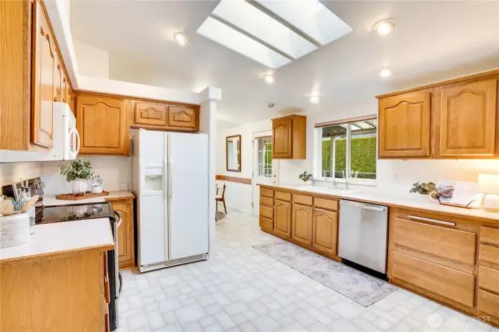 Heading into the kitchen: Three large skylights, great countertop space and storage. Stove and dishwasher are new.