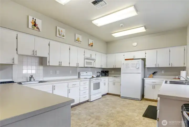 Community kitchen is fully stocked with kitchen gadgets and utensils.