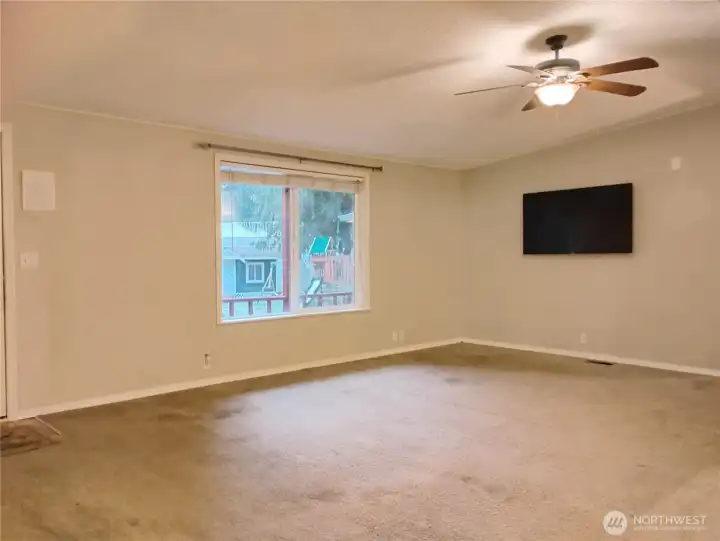 There will be more pictures to come-this is the living room with vaulted ceiling with light fixture fan and a newer pellet stove.  The front door is 36 inches wide and the window has a view of the flat backyard.