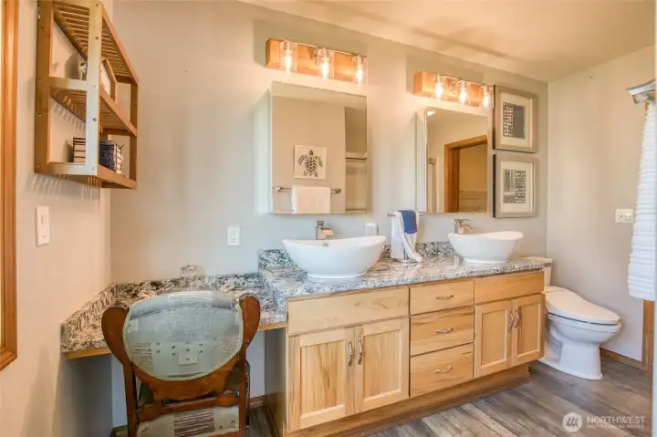 Double vessel sinks over granite countertops in updated primary bathroom. New light fixtures highlight the room. Let's not forget the heated seat and bidet toilets!