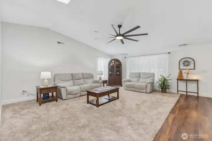 Living room with new carpet and ceiling fan.