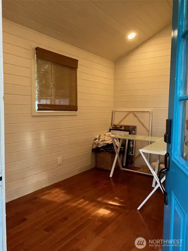 Home Office has custom ship lap walls, recessed lighting and wood laminate floors.