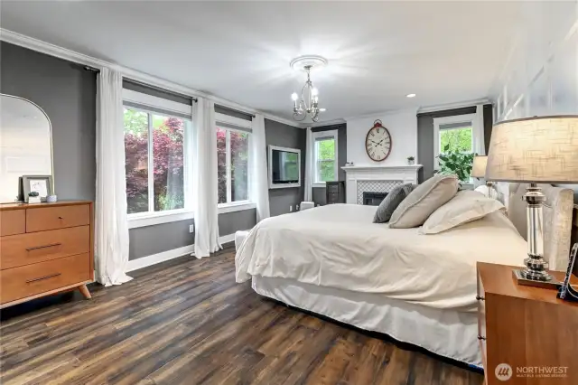 Notice the many windows and natural light in primary bedroom.