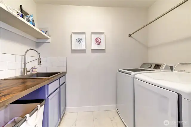 Upstairs laundry room with folding table and hanging rack.