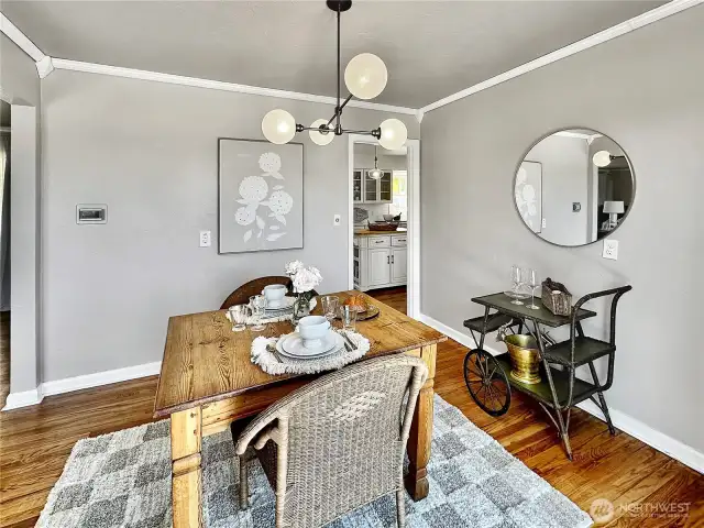 The dining room with crown molding offers easy access to both the kitchen and living room.