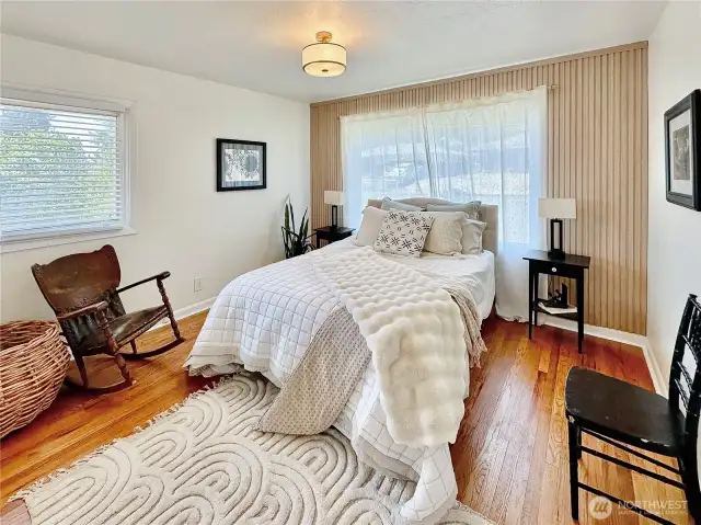 Second bedroom on the main floor also with oak floors and wood accent wall.