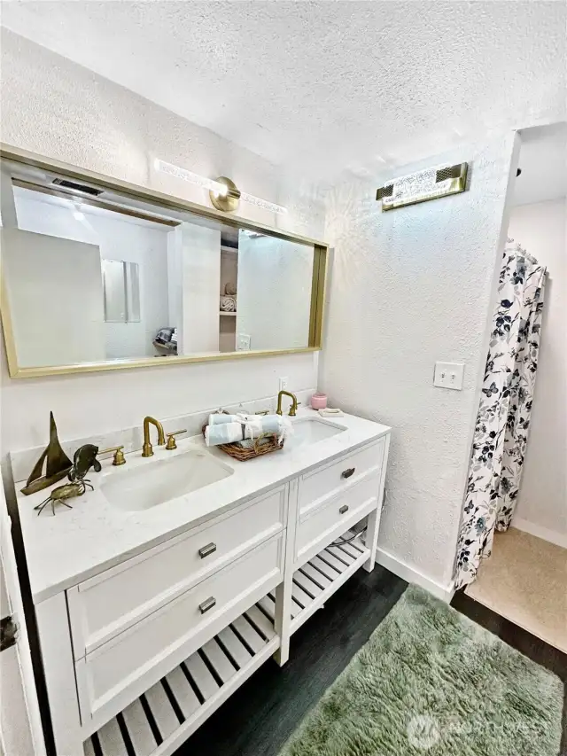 Updated 3/4 bath with new double sink vanity, lighting and flooring.