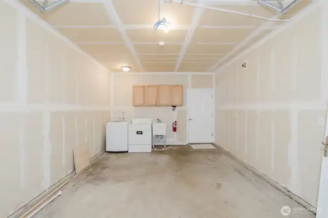 Attached garage with laundry area and storage options