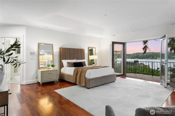 A spacious primary bedroom with private balcony, fireplace, updated lux bath, and expansive closet