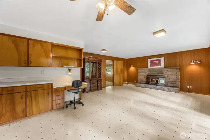 Family room features wood burning fire insert. Fireplace in unknown condition, flames a simulation.