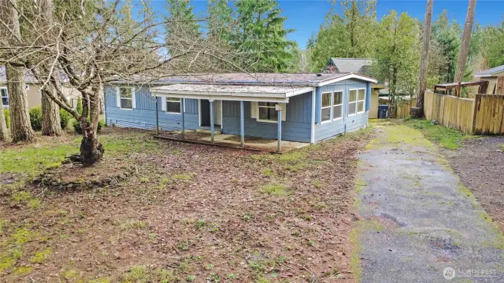 Large covered front porch entry, lifetime metal roof & long paved driveway.