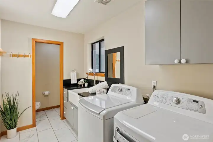 Laundry room with utility sink and conveniently located powder room.