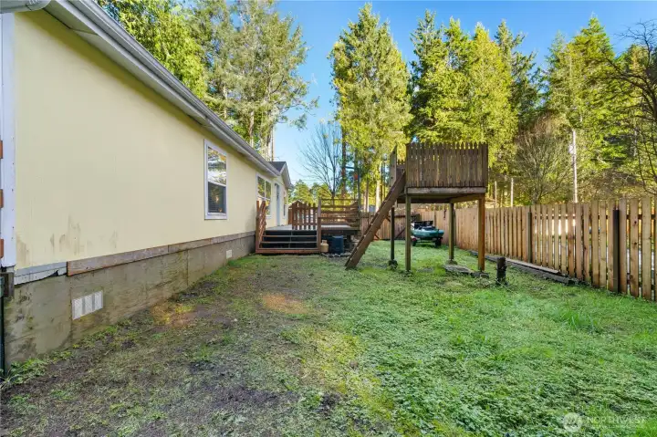 Fenced in side yard with play platform