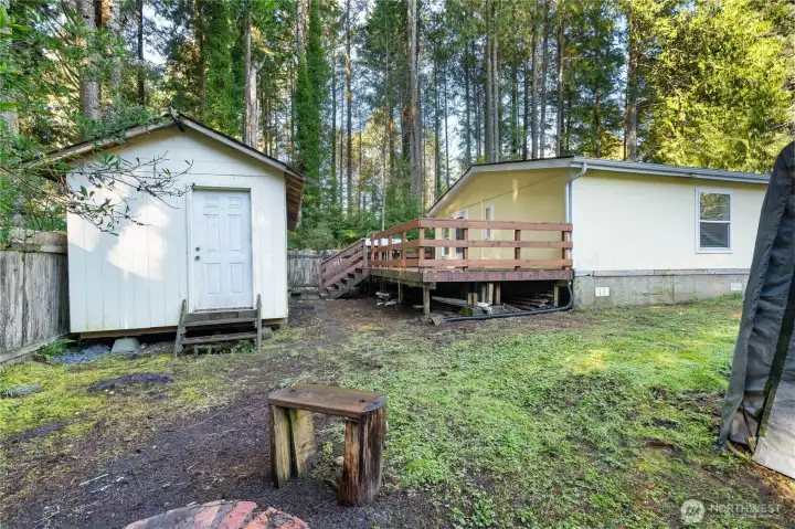 Back of home with firepit and outbuilding