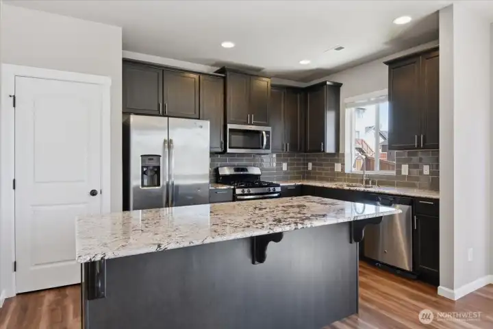 Kitchen with quartz slab countertops and new cabinetry.