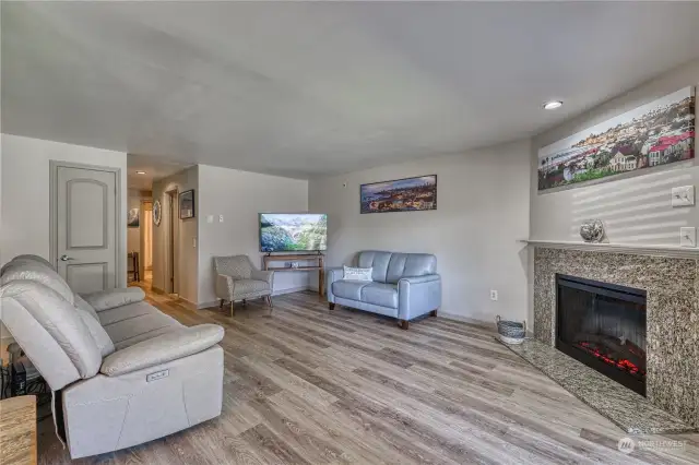 Spacious living room with electric fire place and new luxury plank vinyl throughout.