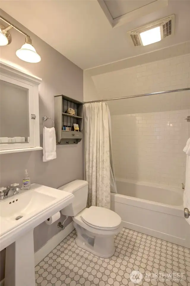 The upstairs hall baths has a tile floor and tile shower surround.