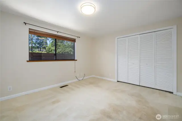 Second bedroom with ensuite bathroom & classic louvered closet doors.