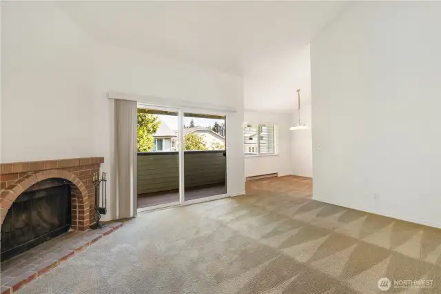 Living room with wood burning fire place, slider to deck and dining area
