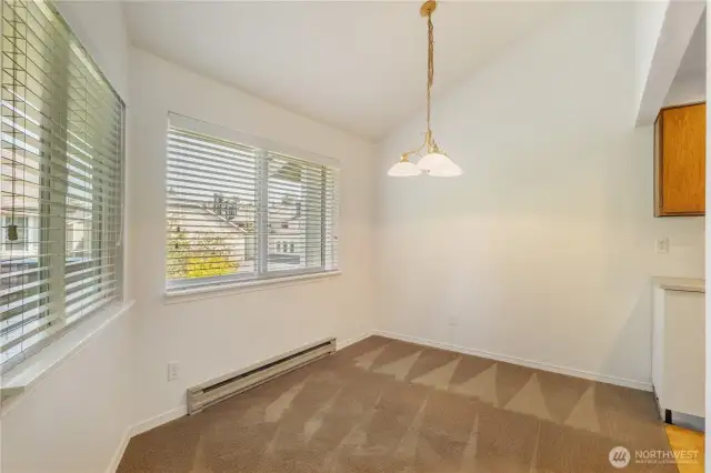 dining room with 2 large windows leading into kitchen