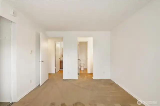 Primary look back towards vanity area and entrance to bath from primary