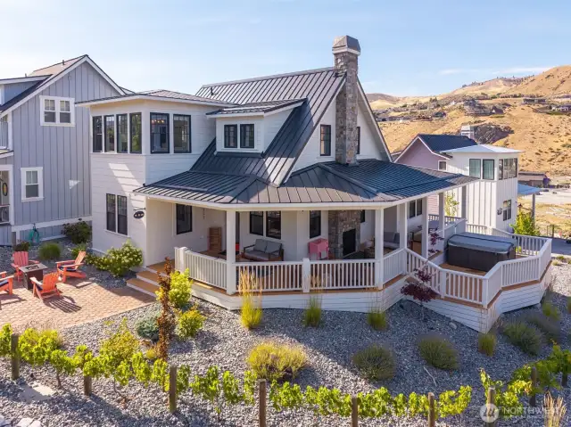 Exterior view of home w/ wraparound porch and outdoor living area.